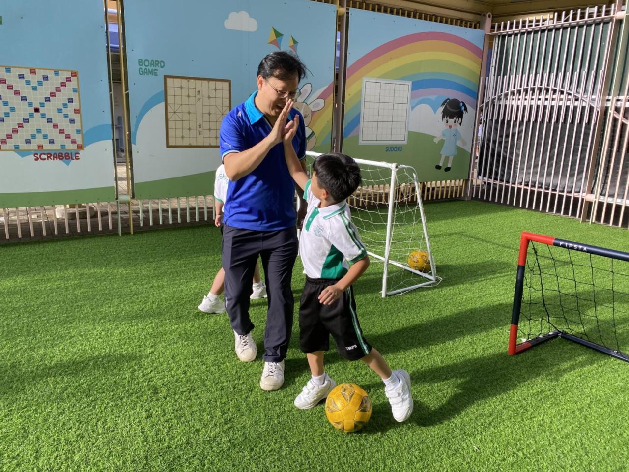 校長早上陪伴同學踢波